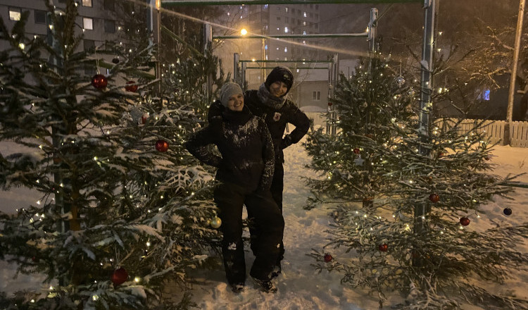 To kvinner blant juletrær i snøen
