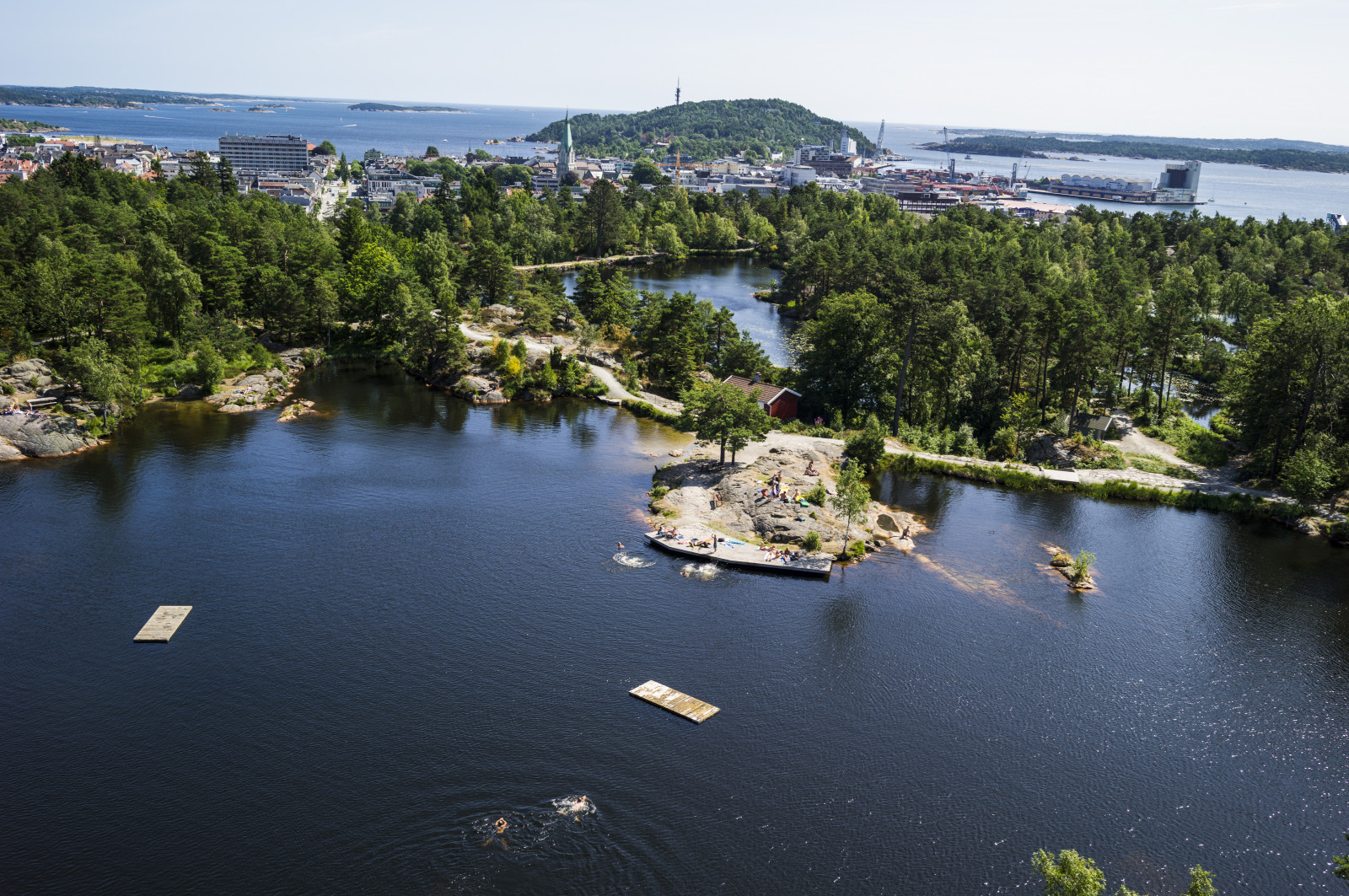 Flyfoto av Kristiansand med naturen i Baneheia i forgrunnen 