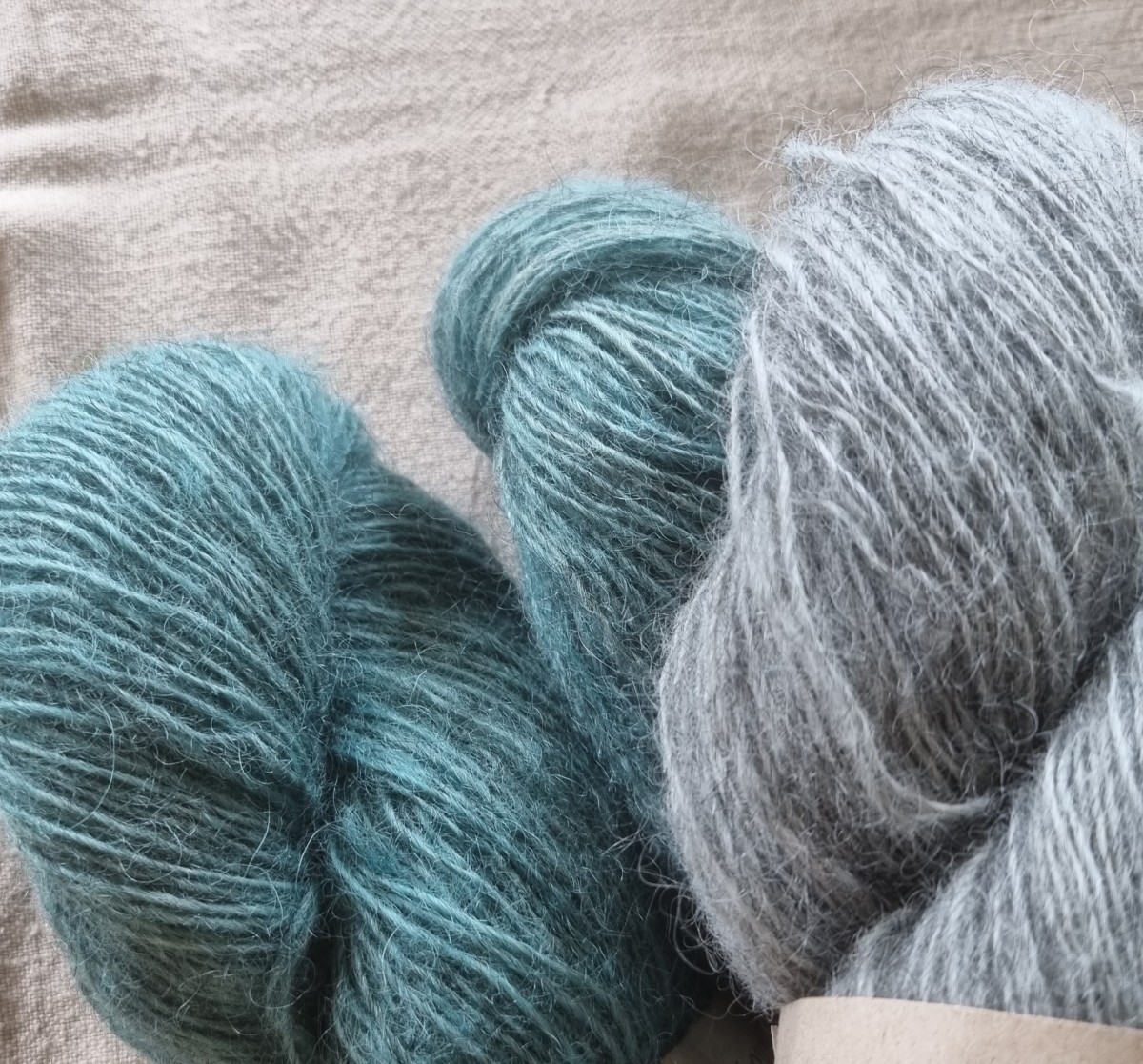 Dette er bilde av noen garnnøster i fargene grønn og grå